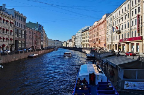 A river, the Moika, separates two rows of buildings in a sunny cityscape, Saint Petersburg, St.