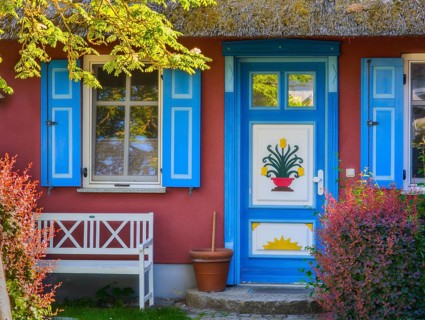 Thatched-roof house with colorful door and window and bench Baltic Sea Germany