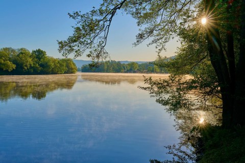 The sun gently illuminates the water surface of a quiet river, Boxtal, Main-Boxtal, Tauber-Kreis,
