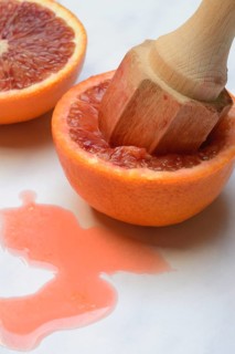 Halved blood orange with citrus squeezer, orange