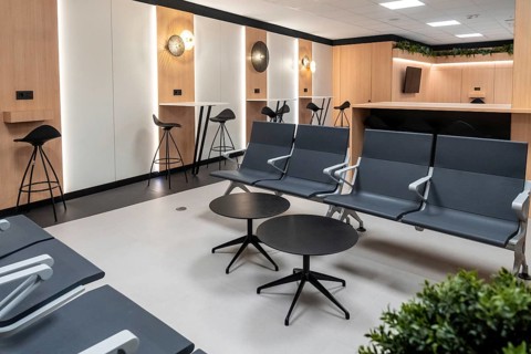 Contemporary airport lounge providing travelers with comfortable seating, workspaces, and charging