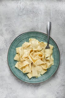 Pasta papardelle in creamy garlic sauce, traditional Italian cuisine, pasta carbonara, homemade, no