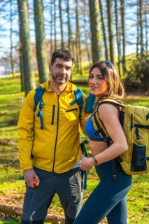 Hikers with backpacks walking through a vibrant forest, soaking in the beauty of nature on a sunny