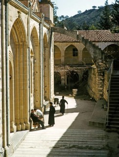 Mönche und andere Menschen sitzen vor der Kirche des Klosters Panagia Machairas, Lazanias, Zypern,
