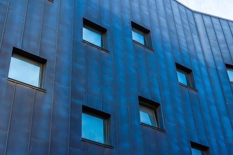 A contemporary building showcasing a multicolored facade, emphasized by a pattern of blue-tinted