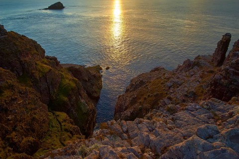 A tranquil sunset over the sea and rocky cliffs, Cap Frehel, Cotes-d Armor, Brittany, France