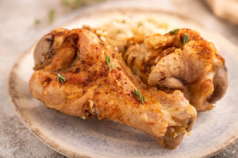 Fried Turkey Wing with spices and rice on brown concrete background and linen textile. side view,