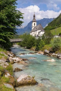 Famous view of the parish church of St. Sebastian with bridge over the Ramsauer Ache in the