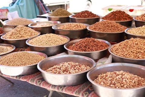 Metal bowls filled with assorted nuts and seeds at a market stall