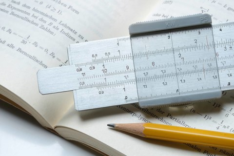 Slide rule on book, calculating aid