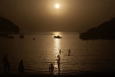 The sun sets on the horizon over the sea on the Spanish Balearic island of Majorca, Colonia de Sant