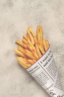 Fried French fries in a paper bag, on an abstract background, without people, in a rustic style, in