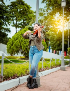 Woman playing violin in the street. Portrait of violinist girl playing in the street. Woman artist