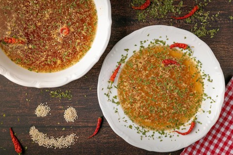 Decorated soup plate next to a smiling quinoa face on rustic table