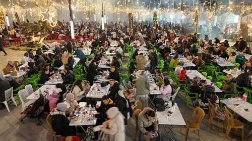 Aerial view captures hundreds of Muslims gathered at long tables for a communal Iftar meal in a