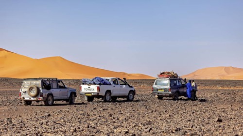 Three off-road vehicles parked together in the desert, people swapping stories, Off-road vehicles