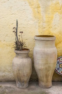 Amphorae as decoration in front of a yellow house facade, Meknes, Morocco