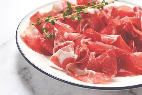 Plate with sliced cured meat, pork neck, prosciutto coppa, Italian delicacy