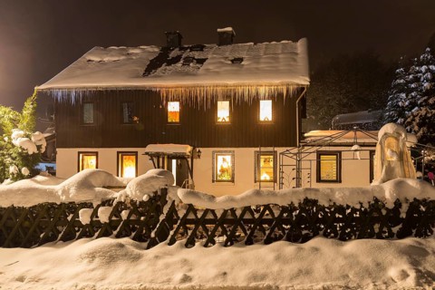 House with Christmas lighting in the snow, Oberlochmühle, Deutschneudorf, Erzgebirge, Saxony,