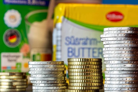 Symbolic image of inflation: pile of euro coins, dairy products from the supermarket in the