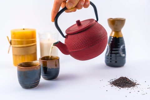 Serving Japanese tea with candles and a cup and Japanese glasses with a white background