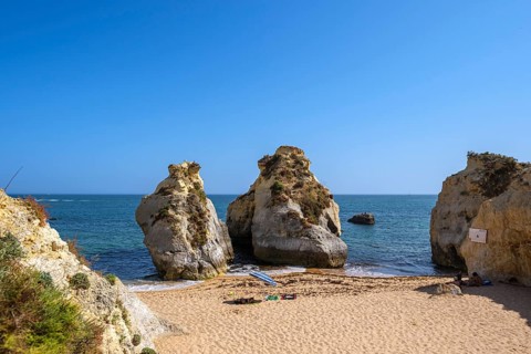 Distinctive rock formations on the beach, blue sea and clear sky, calm atmosphere, Porches, Faro,