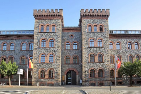 Technical town hall with twin towers with battlements, portal with German national flag, hunting