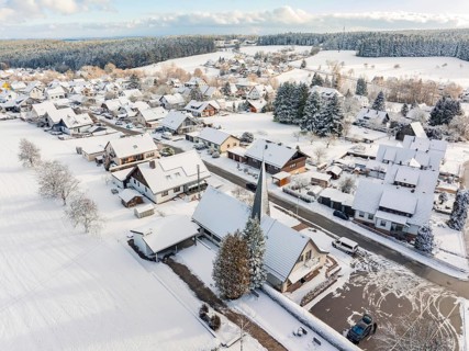 Snow-covered houses with church and streets in a small village, Oberreichenbach, Black Forest,