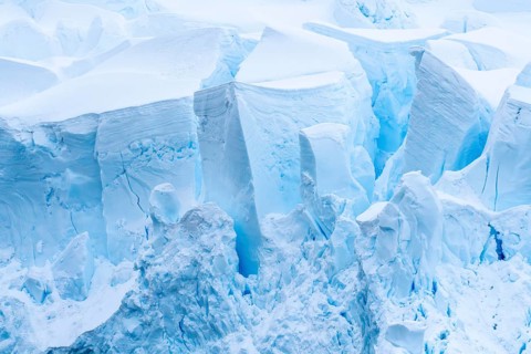 Glacier breakout with crevasses and shimmering blue ice formations, detailed view, Antarctic