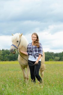 Young woman with a Icelandic horse on a meadow, Germany