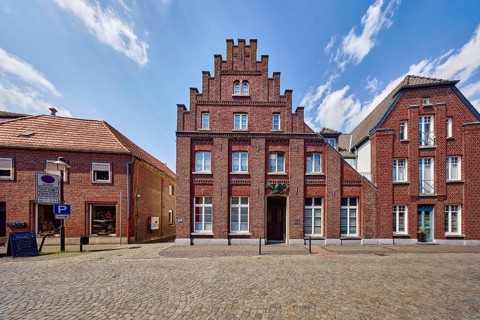 Historic city center, historic brick building Schwarzer Adler, façade with windows, staggered