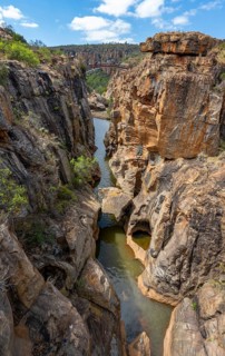 Bridge over a canyon with steep orange-coloured cliffs and the Blyde River, Bourke's Luck Potholes,