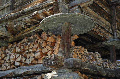 Detail of traditional wooden granary, raccard showing circular stone slab to prevent rodents from