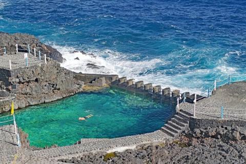 A swimming pool bordered by the sea with clear water on a rocky coast, Charco Azul, San Andres, La