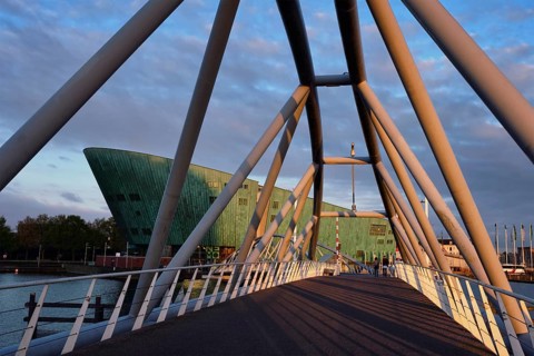 AMSTERDAM, NETHERLANDS, MAY 9, 2017: NEMO Science museum and Mr. J. van der Veldebrug bridge. It is