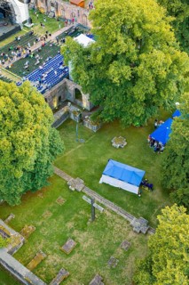 Bird's-eye view of ruins with crosses and tents surrounded by trees, Calwer Klostersommer Festival,