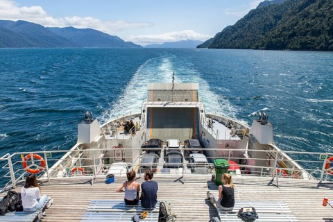 Passengers view the mountains and fjord landscape on the ferry between Hornopirén and Caleta