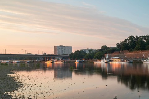 First rays of sunshine on the banks of the Elbe opposite the Old Town, paddle steamer at the jetty