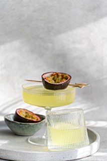 A vibrant cocktail prepared with gin, tonic, and passion fruit juice, garnished with a fresh