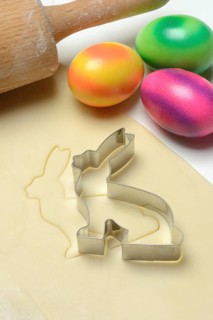 Rolled dough with bunny cookie cutter, rolling pin and Easter eggs
