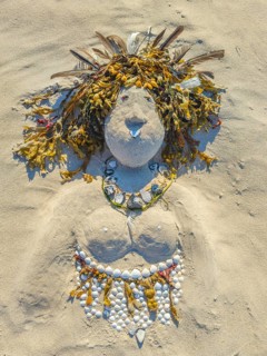 Art on the beach woman portrait made of sand shells tank feathers