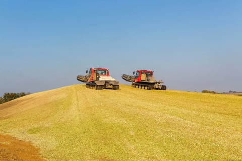 Piston Bully tracked bulldozer vehicles building silage clamp of sweetcorn maize in field stored