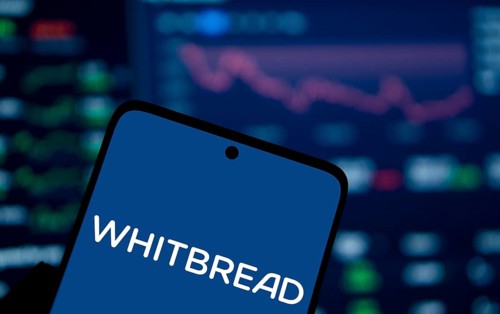 Whitbread logo is displayed on smartphone. Whitbread is a British multinational hotel and