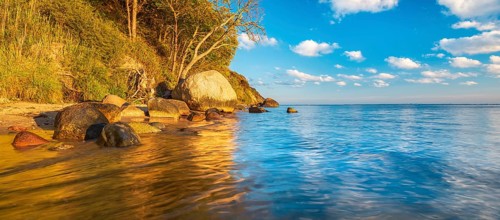 Coastal landscape with large boulders on the Baltic Sea beach in the evening light, Mönchgut Nature