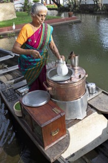 Tealady, 83 years old, making Indian tea on her boat, Backwaters, Kumarakom, Kerala, India
