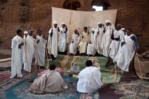 Orthodox priests are singing religious hymns in front of a church at Lalibela, Ethiopia
