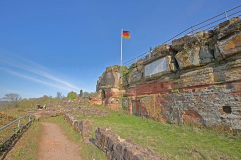 Hohenburg castle ruins with German national flag, red coloured sandstone, rocks, hiking trail,