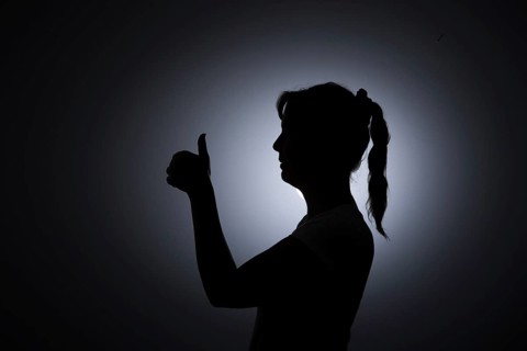 Symbol photo. Silhouette of a young woman giving a thumbs up. Berlin, 22.08.2024