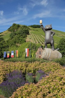 Roundabout with flags and sculpture black cat as a symbol of wine-growing region, wine glass,