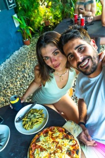 Tourists enjoying a delicious meal of pizza and pasta during their vacation in siargao island,